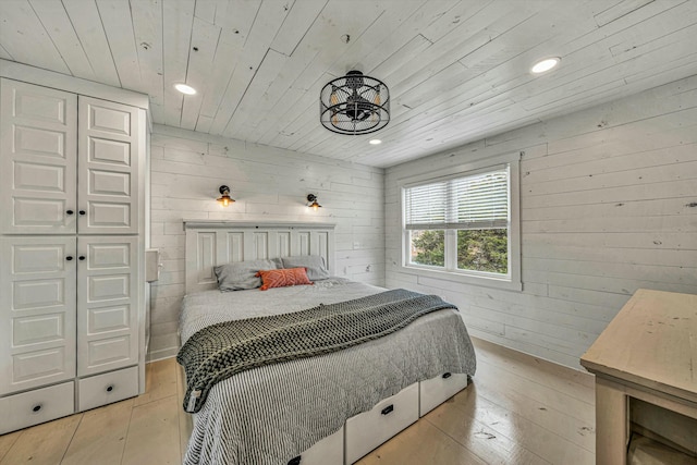 bedroom with wooden walls, wood ceiling, and light wood-type flooring