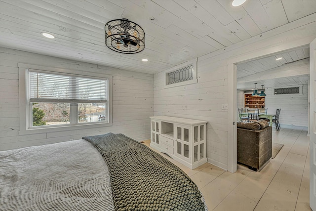 bedroom with wooden walls, light wood-type flooring, and wooden ceiling