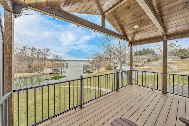 wooden terrace with a yard and a water view