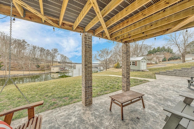 view of patio / terrace featuring a water view and a storage unit