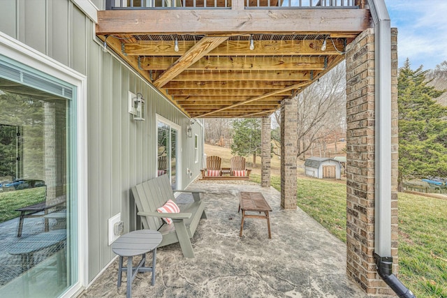 view of patio / terrace featuring a balcony, a deck, and a shed