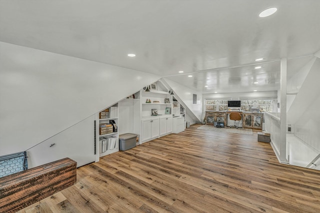 living room with built in features and light hardwood / wood-style floors