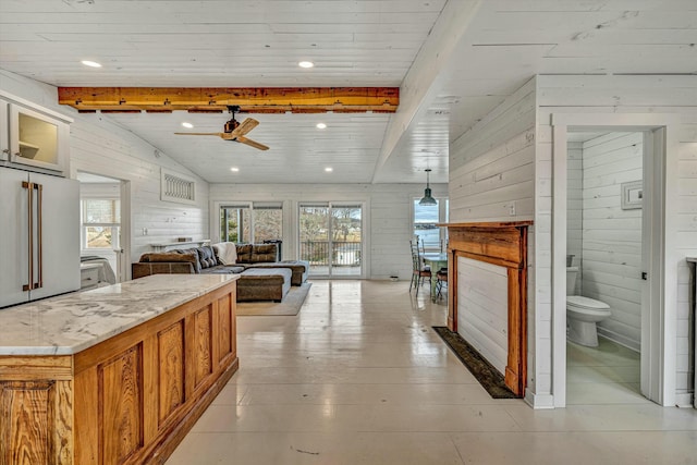 interior space featuring vaulted ceiling with beams, wooden walls, light hardwood / wood-style floors, and plenty of natural light