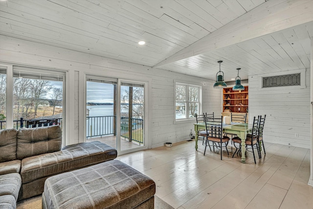 living room featuring light hardwood / wood-style flooring, wooden ceiling, and wood walls