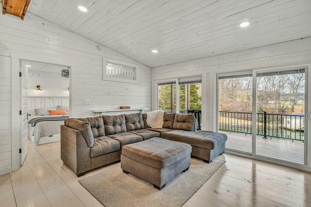 living room featuring vaulted ceiling, wooden ceiling, wooden walls, and light hardwood / wood-style flooring