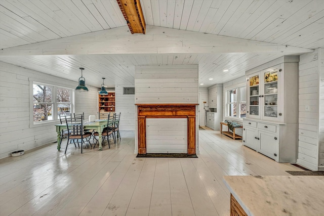 unfurnished dining area featuring wood ceiling, wooden walls, and light wood-type flooring