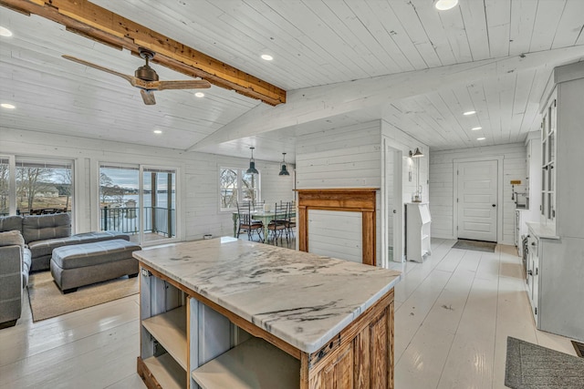 kitchen featuring a kitchen island, white cabinetry, wood ceiling, light stone countertops, and light wood-type flooring