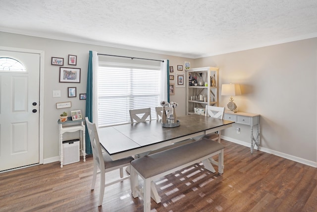 dining room with dark wood-type flooring and a textured ceiling