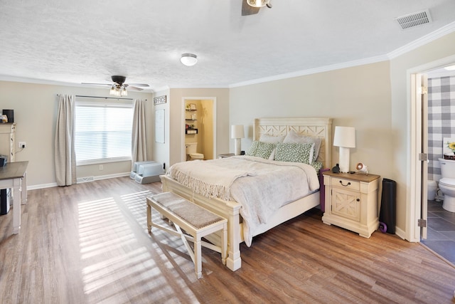 bedroom featuring hardwood / wood-style flooring, connected bathroom, a textured ceiling, and crown molding