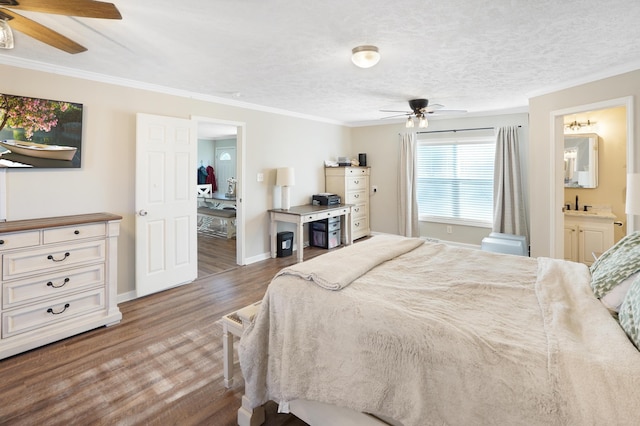 bedroom with ornamental molding, wood-type flooring, ensuite bathroom, and a textured ceiling