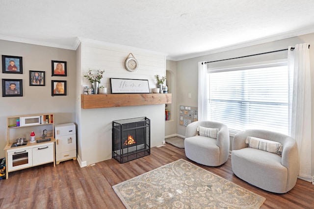 living room with crown molding, wood-type flooring, and a fireplace