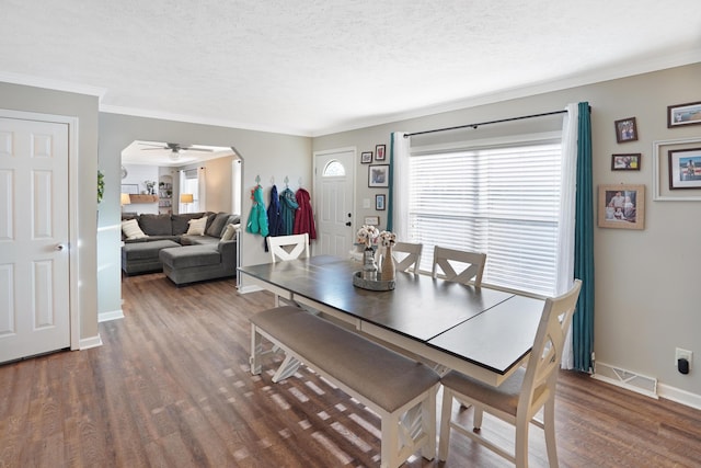 dining area featuring crown molding, ceiling fan, dark hardwood / wood-style flooring, and a textured ceiling