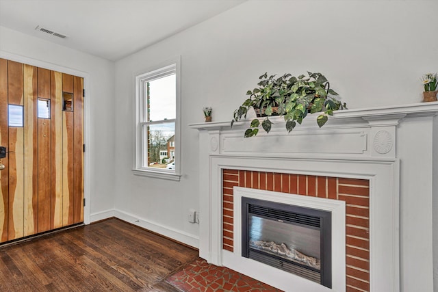 unfurnished living room featuring a fireplace and dark hardwood / wood-style floors