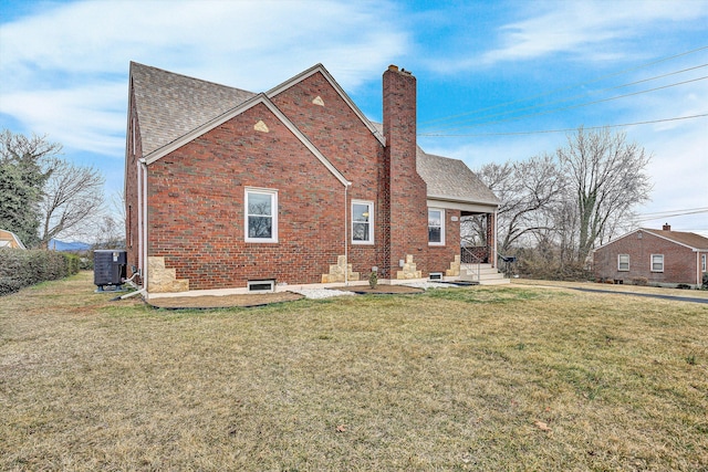 rear view of property featuring a yard and central air condition unit