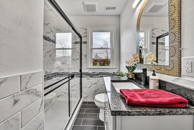 bathroom featuring walk in shower, vanity, and tile walls