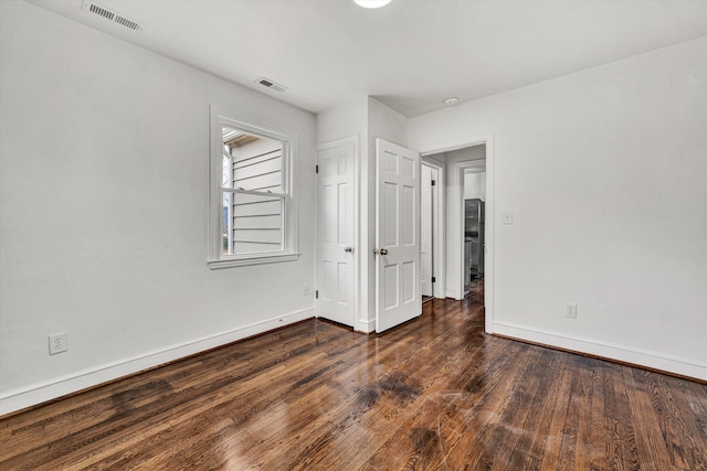 unfurnished room featuring dark wood-type flooring