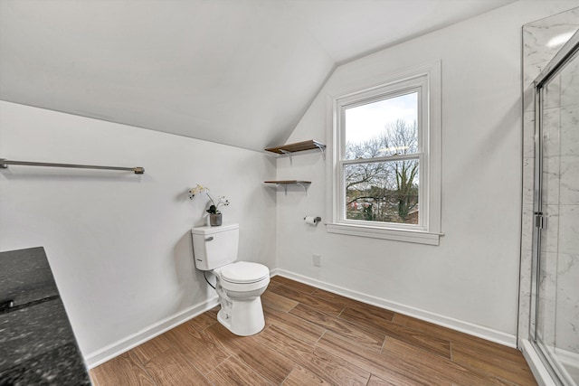 bathroom featuring an enclosed shower, hardwood / wood-style floors, vaulted ceiling, and toilet