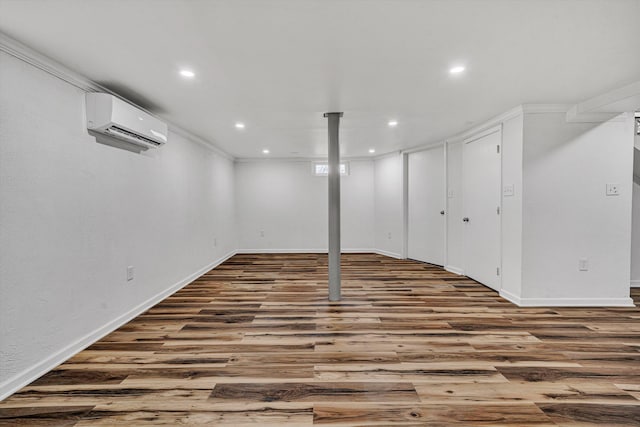 basement featuring ornamental molding, wood-type flooring, and an AC wall unit