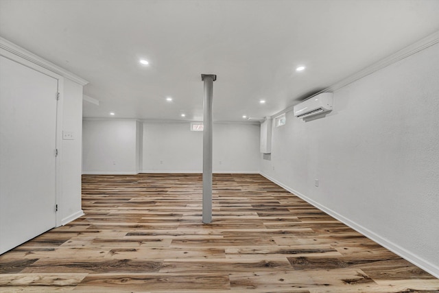 basement with a wall mounted air conditioner and light hardwood / wood-style flooring