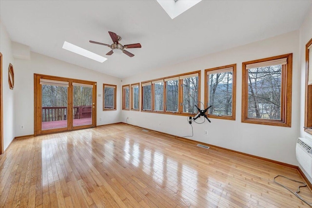 unfurnished sunroom with lofted ceiling with skylight and ceiling fan