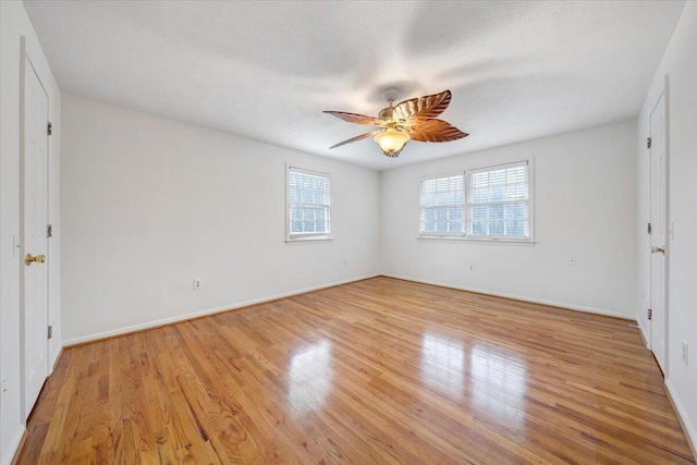 empty room with a textured ceiling, light hardwood / wood-style floors, and ceiling fan