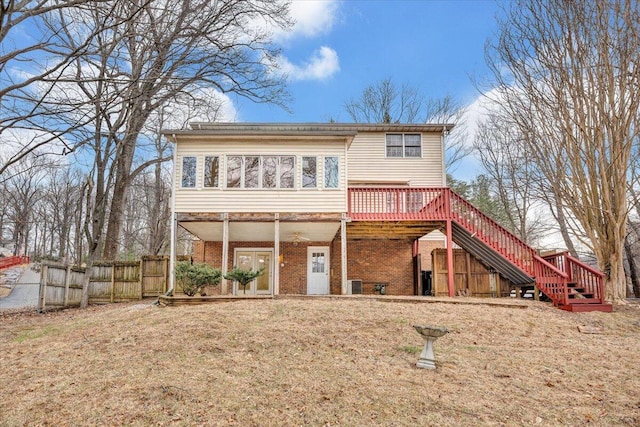 rear view of house featuring a wooden deck and a yard