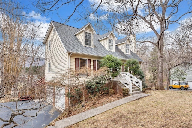 cape cod home featuring a garage and a front yard