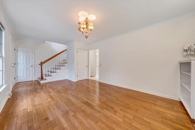 unfurnished living room featuring crown molding, a chandelier, and light hardwood / wood-style floors