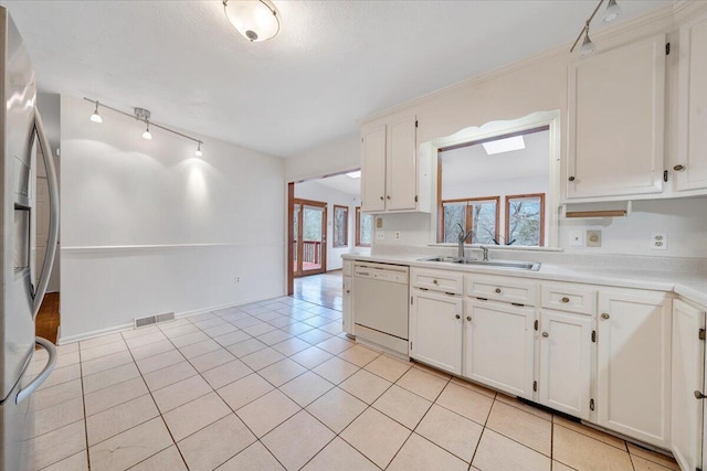 kitchen featuring white cabinets, plenty of natural light, stainless steel fridge, and white dishwasher