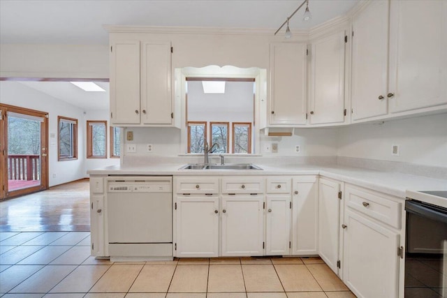 kitchen featuring sink, dishwasher, stove, white cabinets, and light tile patterned flooring