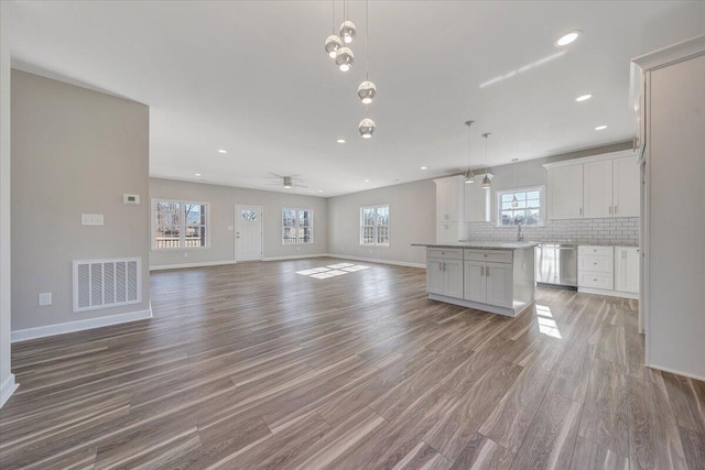 unfurnished living room with ceiling fan and light hardwood / wood-style floors