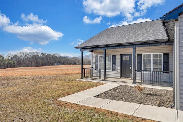 entrance to property featuring covered porch and a lawn