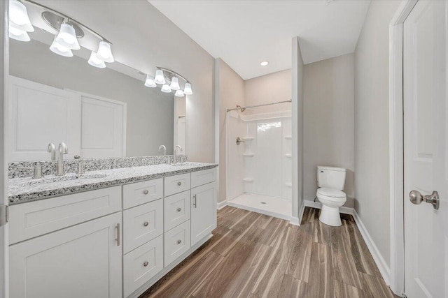 bathroom with vanity, wood-type flooring, toilet, and a shower