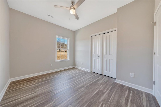 unfurnished bedroom featuring light hardwood / wood-style floors, a closet, and ceiling fan