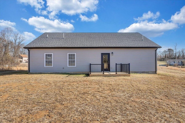 rear view of property featuring a yard