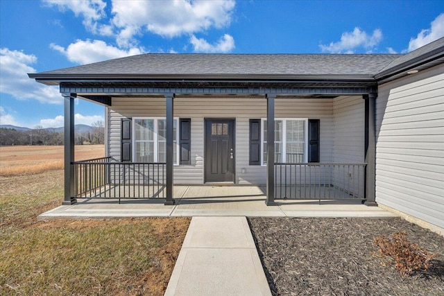 entrance to property featuring covered porch and a lawn