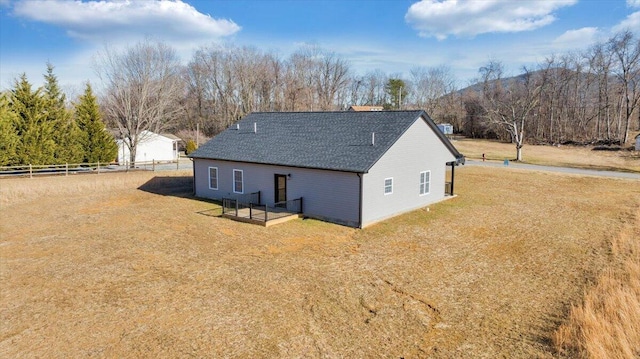 back of property with a mountain view and a lawn