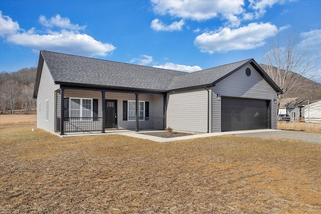 single story home with a garage, a front yard, and a porch