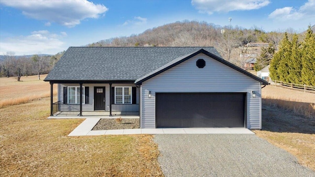 view of front facade featuring a porch, a garage, and a front yard