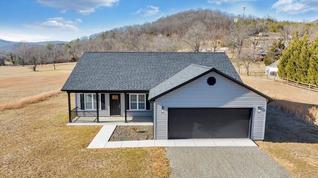 view of front of house featuring a garage, a front yard, and a porch