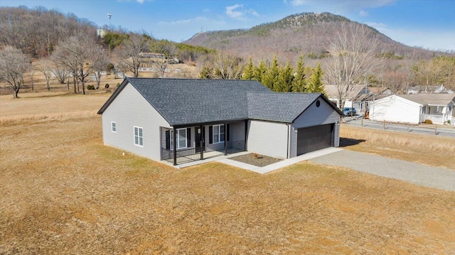 view of front of home with a garage, a mountain view, and a front lawn