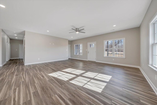 unfurnished living room with dark wood-type flooring and ceiling fan