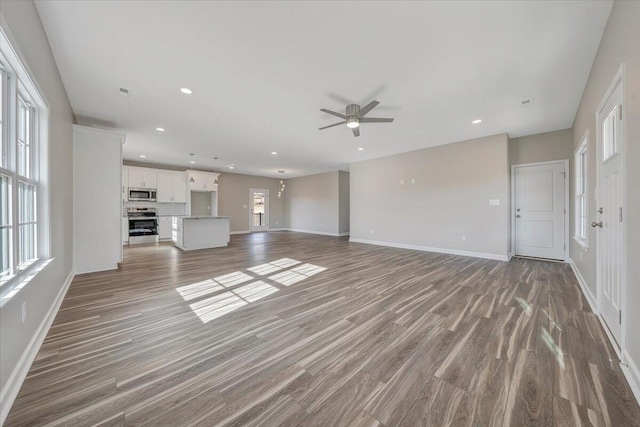 unfurnished living room featuring ceiling fan and light wood-type flooring