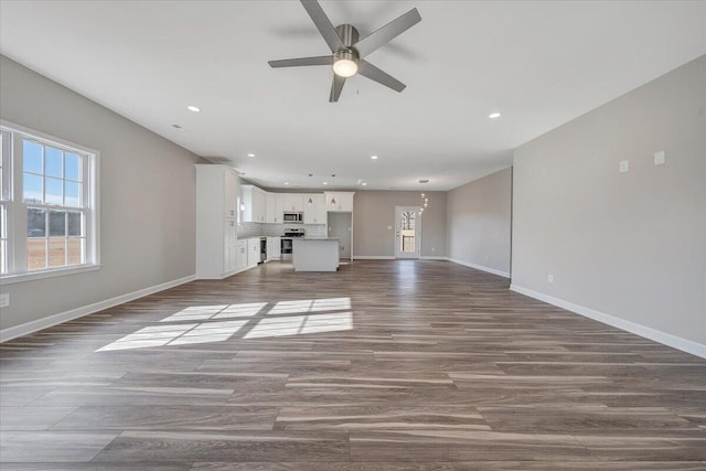 unfurnished living room with dark wood-type flooring and ceiling fan