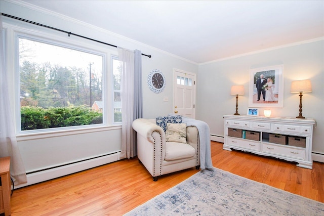 living area with baseboard heating, ornamental molding, and light hardwood / wood-style floors