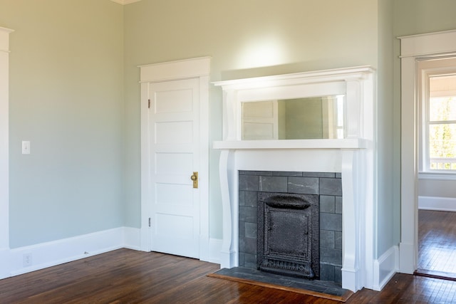 unfurnished living room with a tile fireplace and dark hardwood / wood-style floors