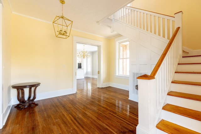 stairs featuring an inviting chandelier, crown molding, and hardwood / wood-style flooring