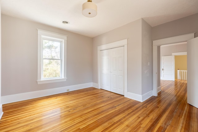 unfurnished bedroom with hardwood / wood-style floors and a closet