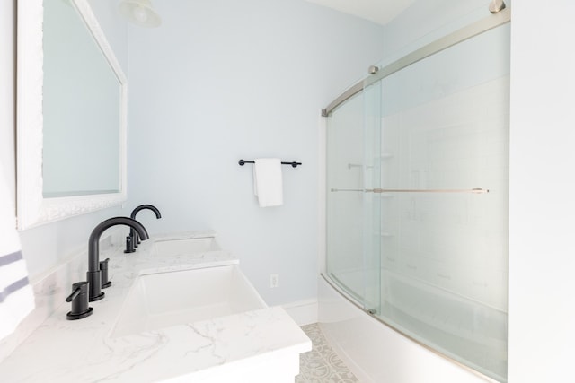 bathroom featuring bath / shower combo with glass door and vanity