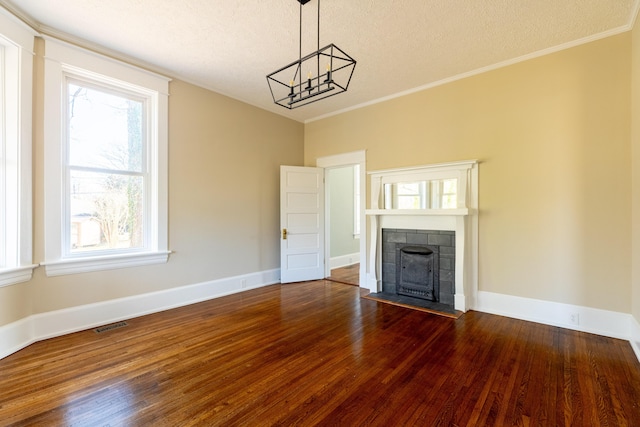 unfurnished living room with wood-type flooring, a textured ceiling, and crown molding